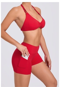 Detail of red high-waisted yoga shorts featuring a side pocket for a smartphone