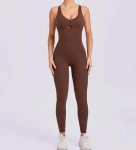 Detail of deep V-neck yoga jumpsuit with ruching and cutout in dark brown fabric