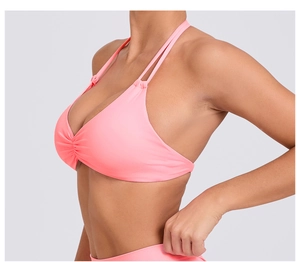 Dettaglio laterale del top yoga rosa con allacciatura al collo regolabile e dettagli arricciati