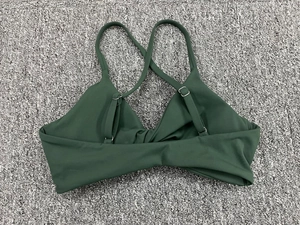 Détail du soutien-gorge de sport vert foncé avec fines bretelles réglables et boucles