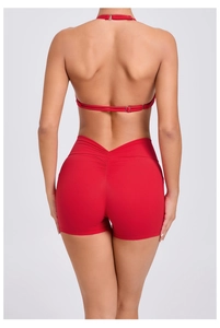 Detail of red yoga set showing V-shaped pleated high waist shorts for butt lifting effect