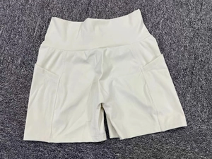 Flat lay of cream yoga shorts with high waist design and functional side pockets for gym wear