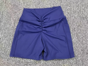 Detailed view of high-waisted purple yoga shorts with side pockets and scrunch butt design