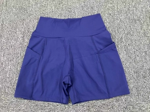 Detailed flat lay of high-waist yoga shorts showing deep side pockets and reinforced seams