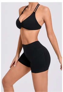 Detail view of black yoga set featuring ruched sports bra and high-waisted shorts with side pocket