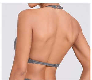 Dettaglio del dorso del top yoga grigio con spalline sottili e fibbie in metallo