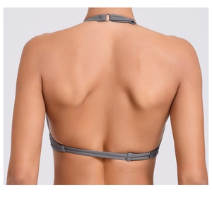 Dettaglio della fibbia in metallo e del cinturino posteriore del reggiseno sportivo grigio