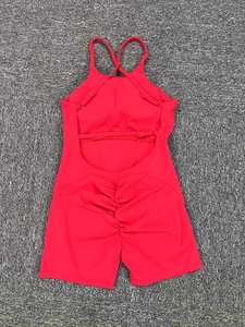 Macro detail of red ruched butt yoga jumpsuit with criss-cross back straps and elastic fabric