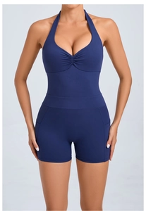 Detail view of the deep V-neckline with pleated ruching and halter neck on yoga romper