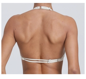 Dettaglio del retro di un top da yoga beige con doppie fibbie in metallo regolabili