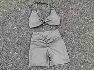 Detail of grey yoga set showing twisted crop top and high-waist shorts with side pocket