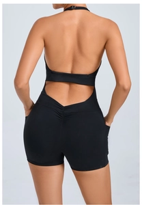Detail of black backless halter yoga romper showing ruched butt lifting and side pockets