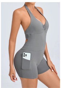 Detail view of gray halter yoga bodysuit featuring a side functional pocket for phone storage