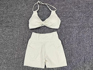 Detail of cream halter top with twist front and high-waist sports shorts with side pockets