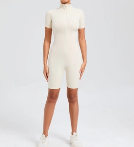 Front view of cream short sleeve yoga jumpsuit with zipper closure and bodycon fit