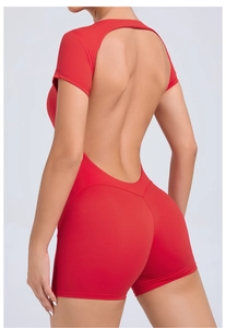 Close-up of vibrant red backless yoga bodysuit featuring professional cross-strap detailing