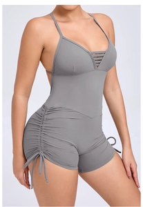 Detail view of adjustable side drawstrings and ruching on a grey cutout yoga bodysuit