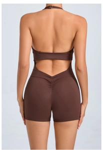Detail view of backless yoga bodysuit with halter neck and ruched booty shorts in brown