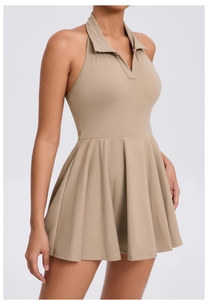 Detailed view of khaki pleated tennis dress featuring halter neck and breathable fabric