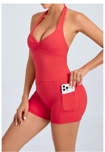 Detail showing the side pocket of a red backless yoga bodysuit with a phone inside