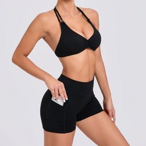 Women's black high-waist yoga set with racerback bra and shorts featuring phone pockets
