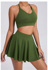 Detail of olive green V-neck sports bra and pleated tennis skirt set on a model