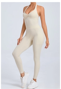 Detail view of beige halter neck yoga jumpsuit with side pockets and ribbed texture