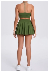 Back view of dark green sports bra and pleated tennis skirt set for outdoor yoga