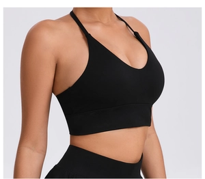 Side view of black sports bra featuring adjustable cross straps and wide elastic hem