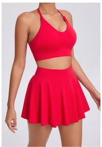 Detail of red sports bra and pleated high-waisted skirt for tennis and outdoor fitness