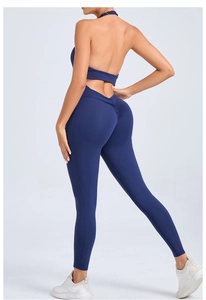 Detailed back view of deep blue ruched yoga jumpsuit with halter neck and backless design