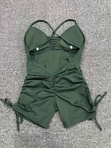Detail view of dark green ruched backless yoga jumpsuit with cutout straps and drawstring side