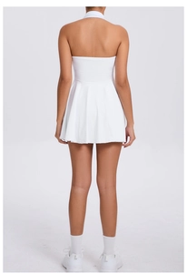 Detail view showing the elegant open back and pleated hem of the white sports tennis dress