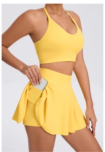 Detail view of yellow tennis skirt with functional side pocket for mobile phone storage