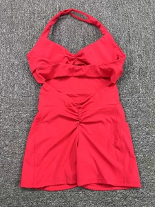 Detail view of red halter yoga romper with side pockets and ruched back design