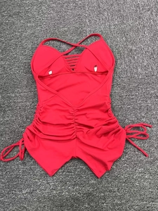 Close-up of bright red yoga jumpsuit featuring back cutout and side drawstring details