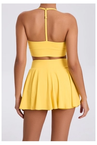 Rear view of bright yellow sports set featuring racerback bra and pleated tennis skirt