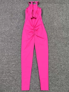 Flat lay of pink backless yoga jumpsuit with ruched waist detail on grey carpet