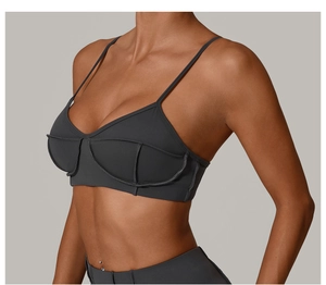 Detail shot of a dark grey sports bra with thin straps and supportive stitching design