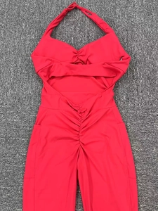 Flat lay of red halter neck yoga jumpsuit with backless cutout and side pockets