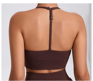 Macro detail of adjustable thin straps and dark brown matte fabric on sports bra