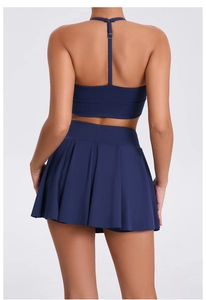 Navy blue backless sports bra and pleated tennis skirt set showing high elasticity fabric