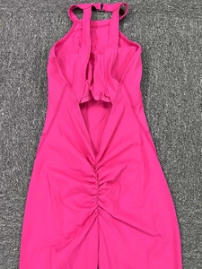 Detail of hot pink open back yoga bodysuit featuring ruched texture and buckle strap