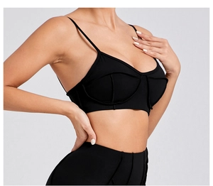 Detailed close-up of stitching on a black sports bra with thin shoulder straps
