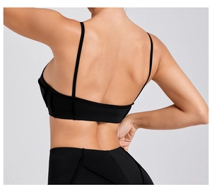 Detail of black sports bra featuring thin straps and back cutout for fitness training