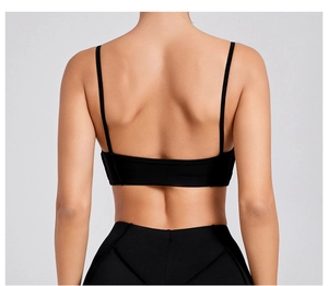 Close-up of black sports bra featuring thin straps and an open-back design on a model