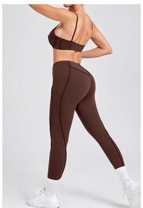 Detailoverzicht van donkerkoffie yogaset met fijne bandjes en corrigerende naden