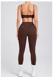 Detail van bruine yogaset met V-vormige billencontuurnaden en smalle bandjes
