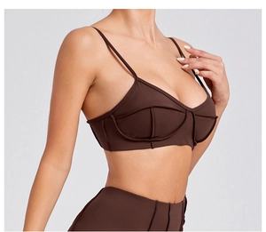 Close-up of dark brown sports bra with geometric seams and elastic knit fabric texture