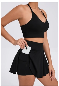 Detail showing functional side pocket on black tennis skirt with sports bra set